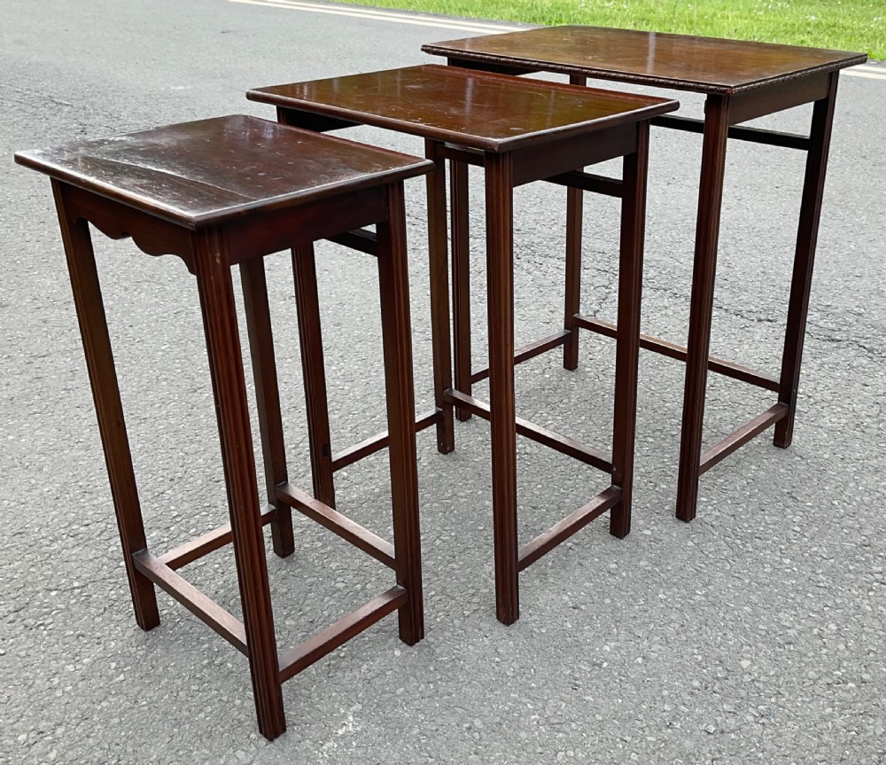 A set of three graduated mahogany nesting tables featuring reeded straight legs and beaded rim moulding. View VIII
