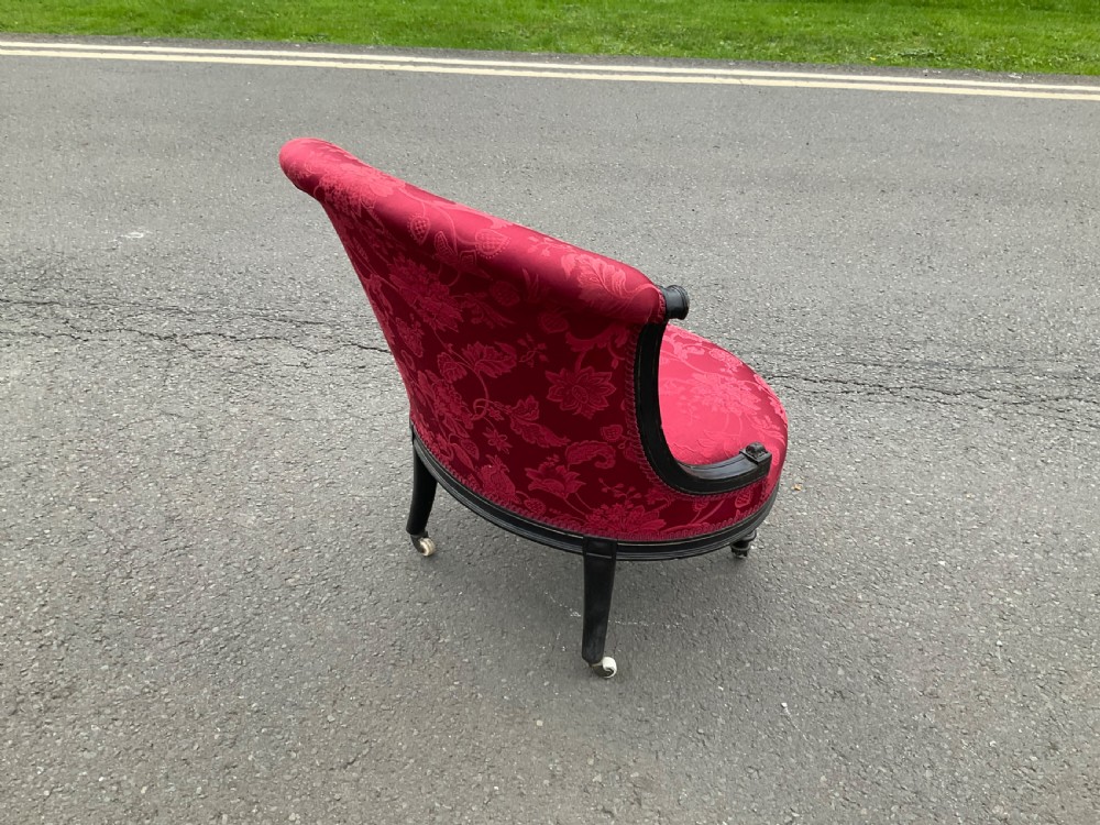 Victorian Aesthetic Movement nursing chair featuring a black ebonised wood frame, turned legs on casters, and red damask upholstery. View VIII