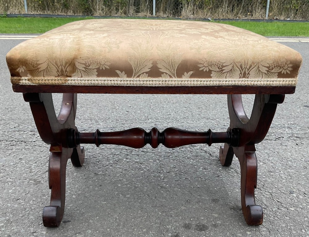 A Victorian mahogany dressing stool featuring shaped X-frame legs, a turned central stretcher, and a gold damask upholstered seat.