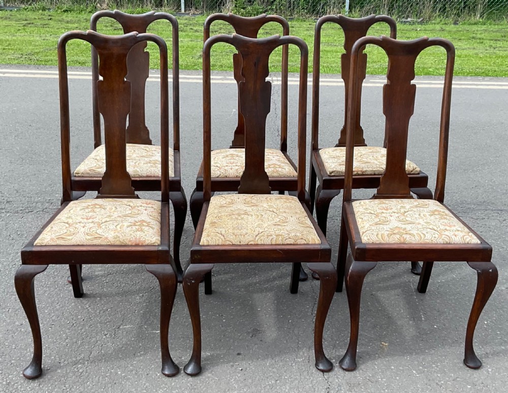 A set of six dark brown stained beech Queen Anne style dining chairs featuring vase splat backs, cabriole legs, and upholstered drop-in seats.