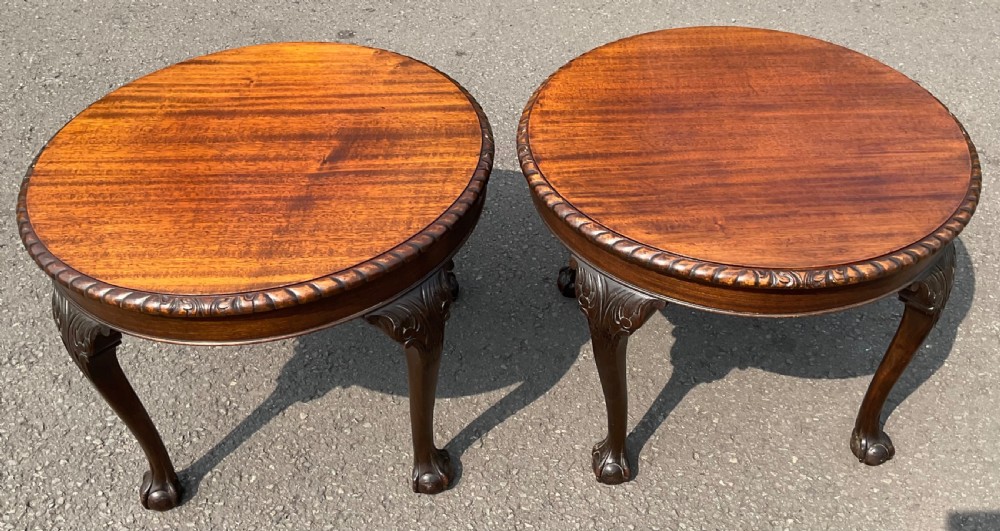 A pair of round mahogany coffee tables featuring carved rope edges and cabriole legs with claw and ball feet.