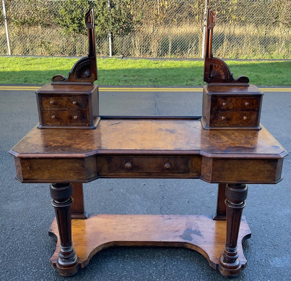 A Victorian burr walnut dressing table featuring a central adjustable rectangular mirror, tiered side drawers, turned front legs, and a shaped lower shelf. View III