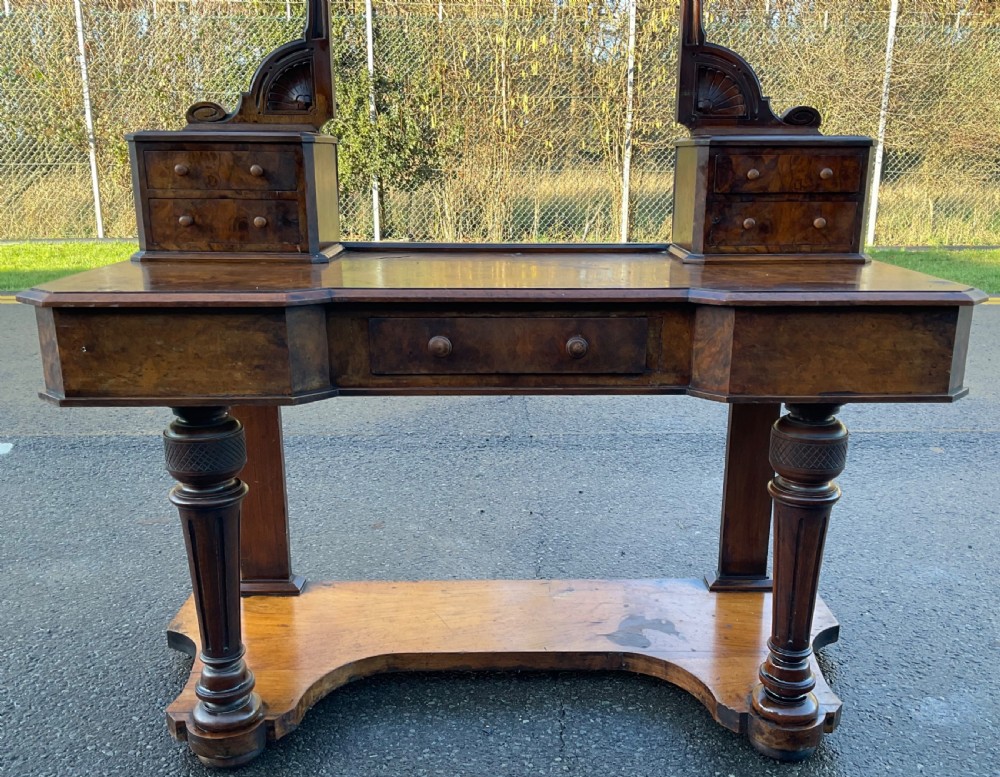 A Victorian burr walnut dressing table featuring a central adjustable rectangular mirror, tiered side drawers, turned front legs, and a shaped lower shelf. View VIII