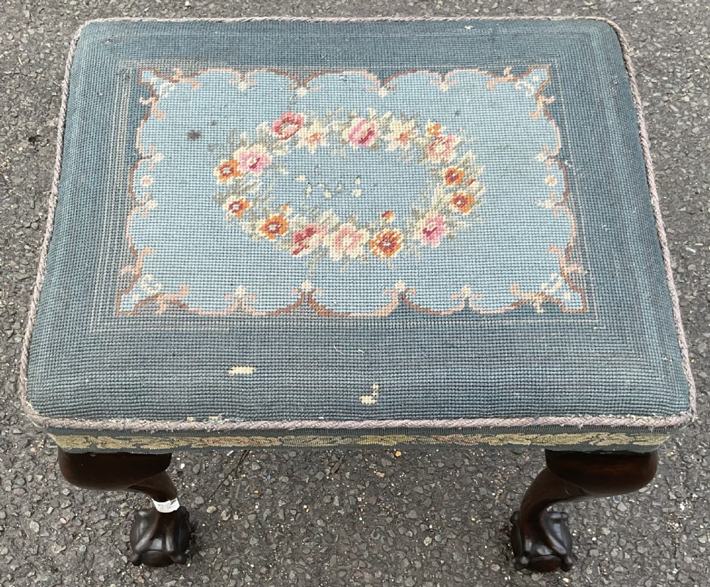 A low rectangular Chippendale style mahogany stool featuring cabriole legs with ball and claw feet and a blue floral tapestry seat. View VI