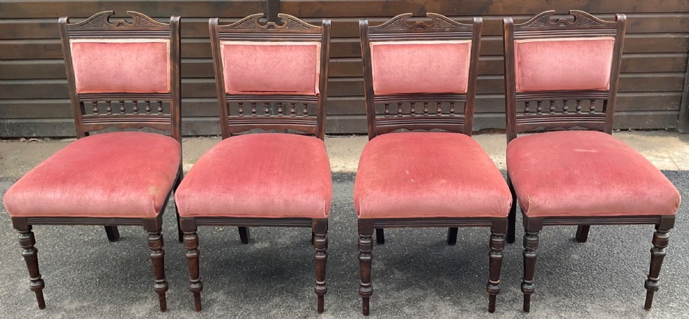 A set of four Edwardian walnut dining chairs upholstered in dusty rose pink velvet with carved cresting rails and turned front legs. View II