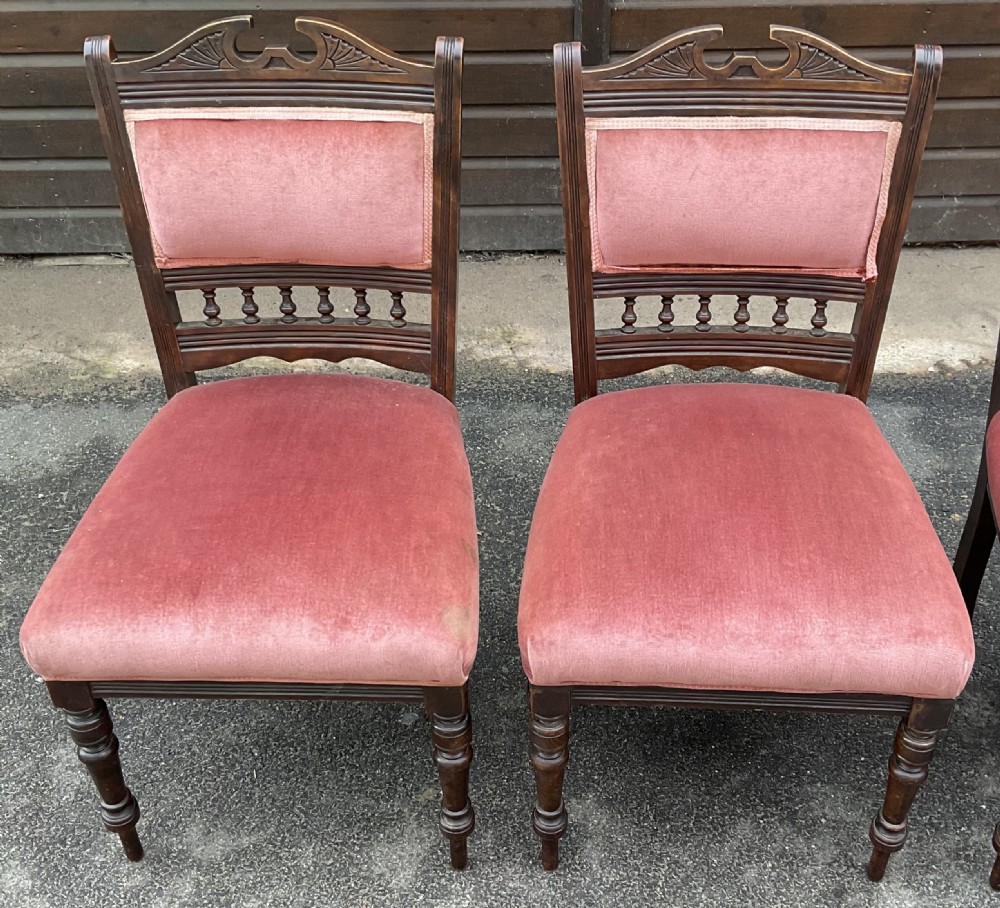 A set of four Edwardian walnut dining chairs upholstered in dusty rose pink velvet with carved cresting rails and turned front legs. View III