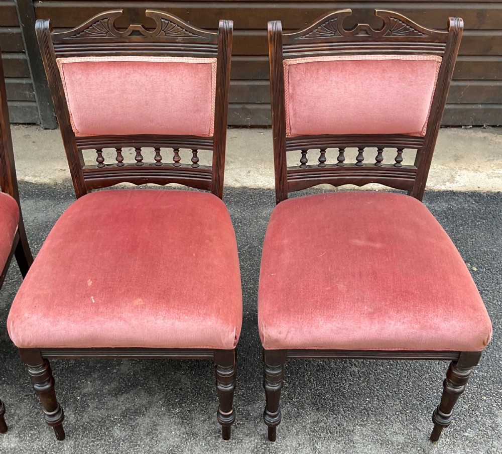 A set of four Edwardian walnut dining chairs upholstered in dusty rose pink velvet with carved cresting rails and turned front legs. View IV