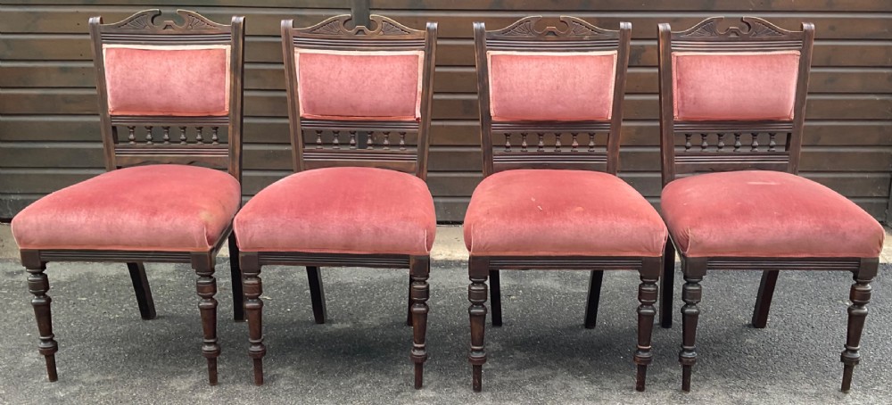 A set of four Edwardian walnut dining chairs upholstered in dusty rose pink velvet with carved cresting rails and turned front legs. View V