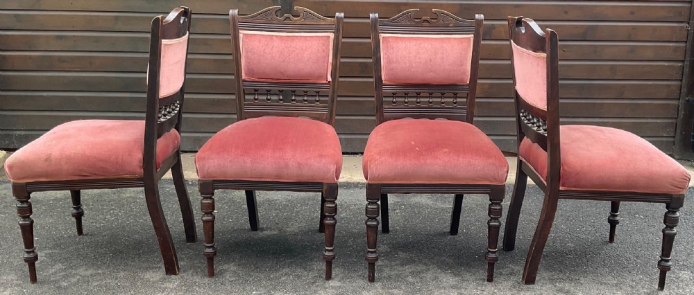 A set of four Edwardian walnut dining chairs upholstered in dusty rose pink velvet with carved cresting rails and turned front legs. View VI