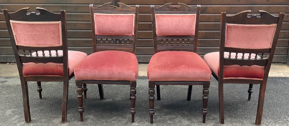 A set of four Edwardian walnut dining chairs upholstered in dusty rose pink velvet with carved cresting rails and turned front legs. View VII
