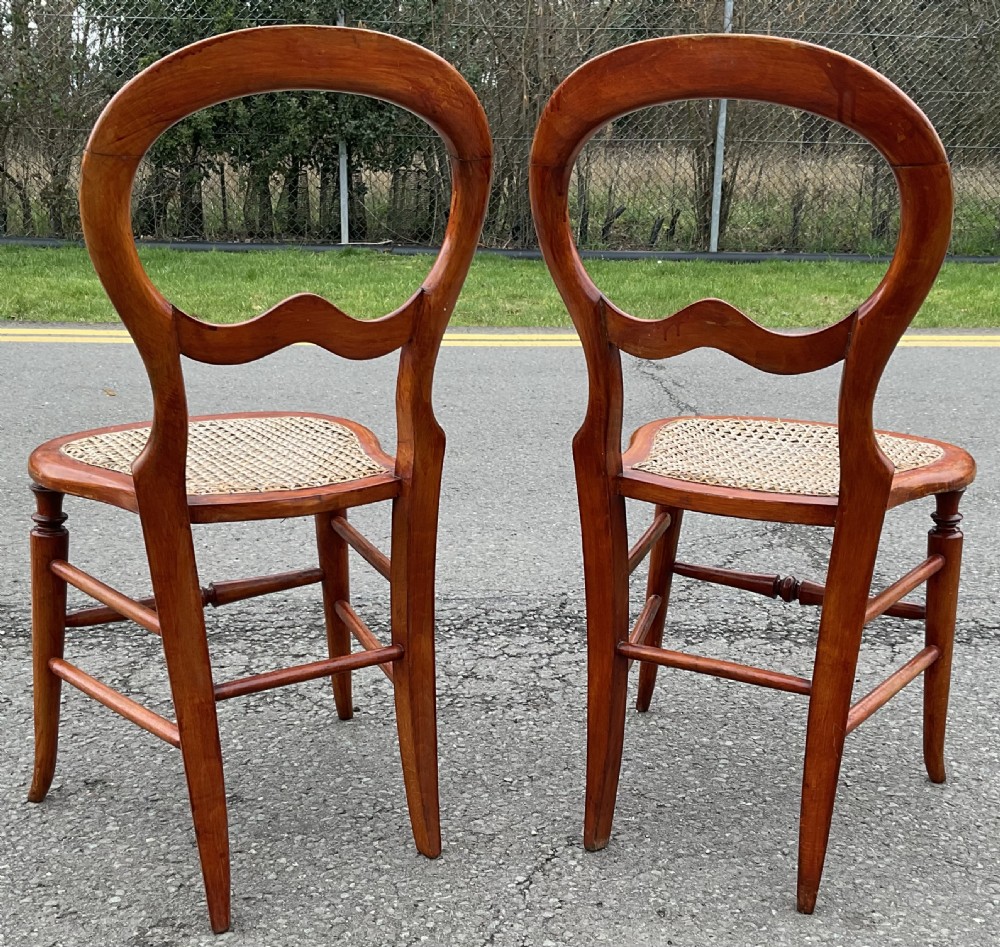 A pair of Victorian mahogany balloon-back side chairs with woven cane seats and turned legs. View III