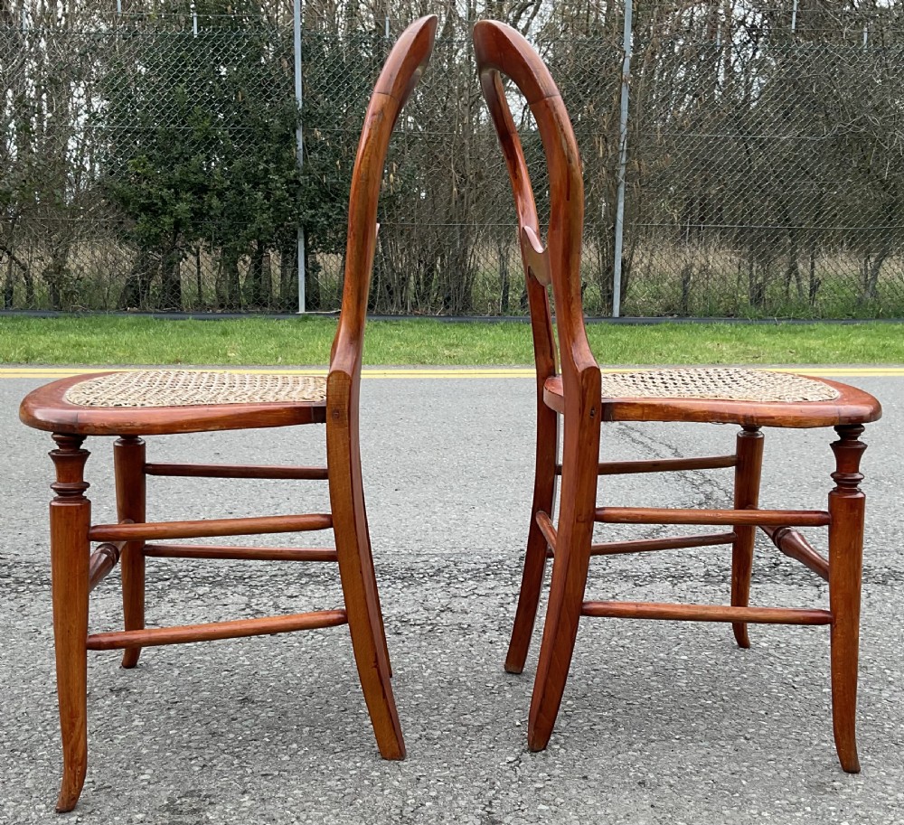 A pair of Victorian mahogany balloon-back side chairs with woven cane seats and turned legs. View IV