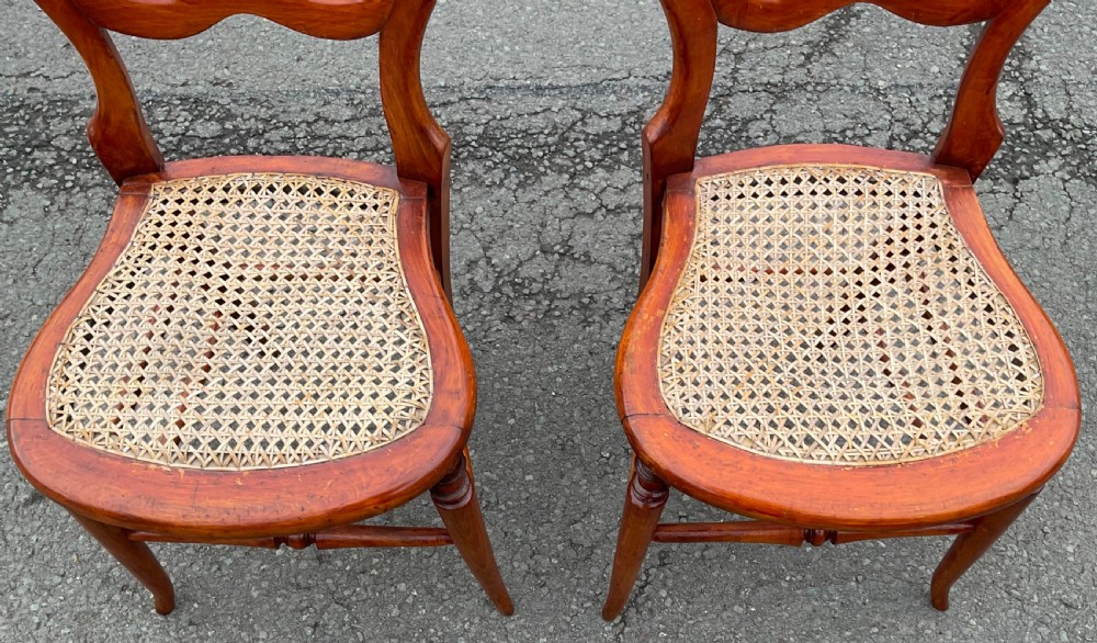 A pair of Victorian mahogany balloon-back side chairs with woven cane seats and turned legs. View V