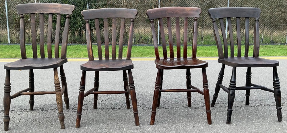 A set of four dark brown Victorian wooden lathback kitchen chairs with turned legs and contoured seats. View II