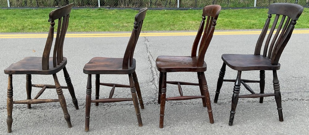 A set of four dark brown Victorian wooden lathback kitchen chairs with turned legs and contoured seats. View IV