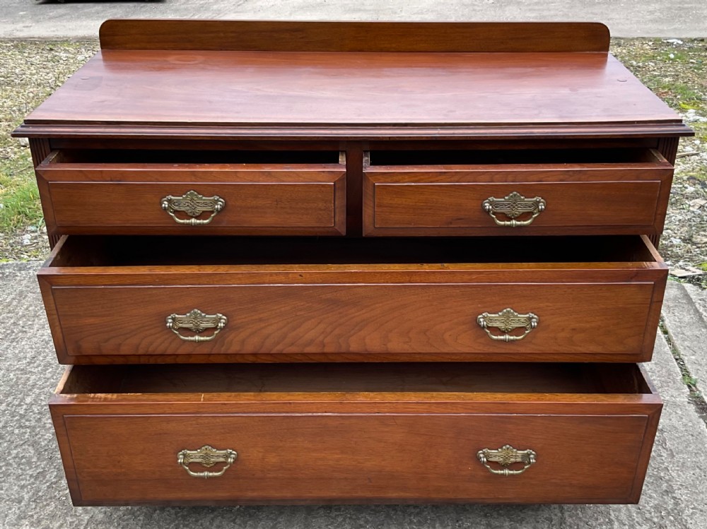 An Edwardian mahogany chest of drawers with two short drawers over two long drawers, decorated with brass drop handles and a low rear upstand. View VII