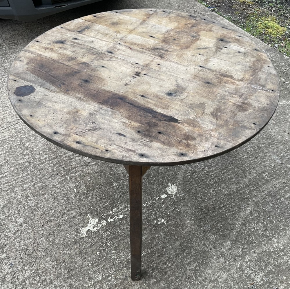 A round antique pine kitchen table featuring a weathered planked wooden top supported by square legs. View II