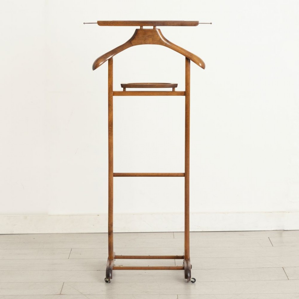 An Edwardian beech wood valet stand featuring a contoured coat hanger, small accessories dish, trouser bar, and a four-footed base on castors. View II