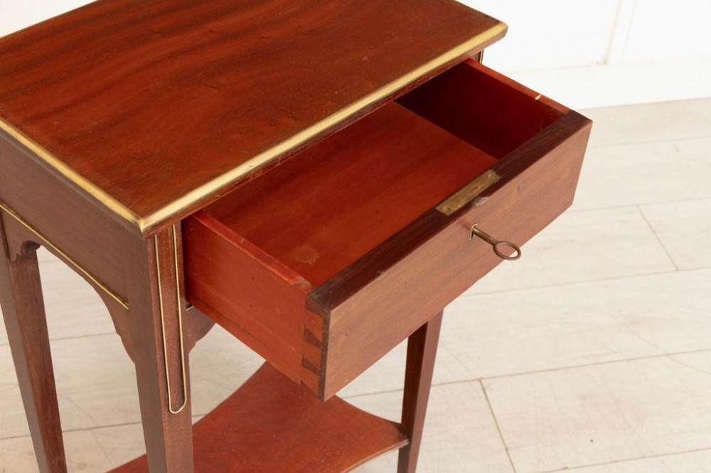 A tall French mahogany bedside table featuring a single drawer with brass stringing inlay, tapered legs, lower shelf, and brass feet. View III