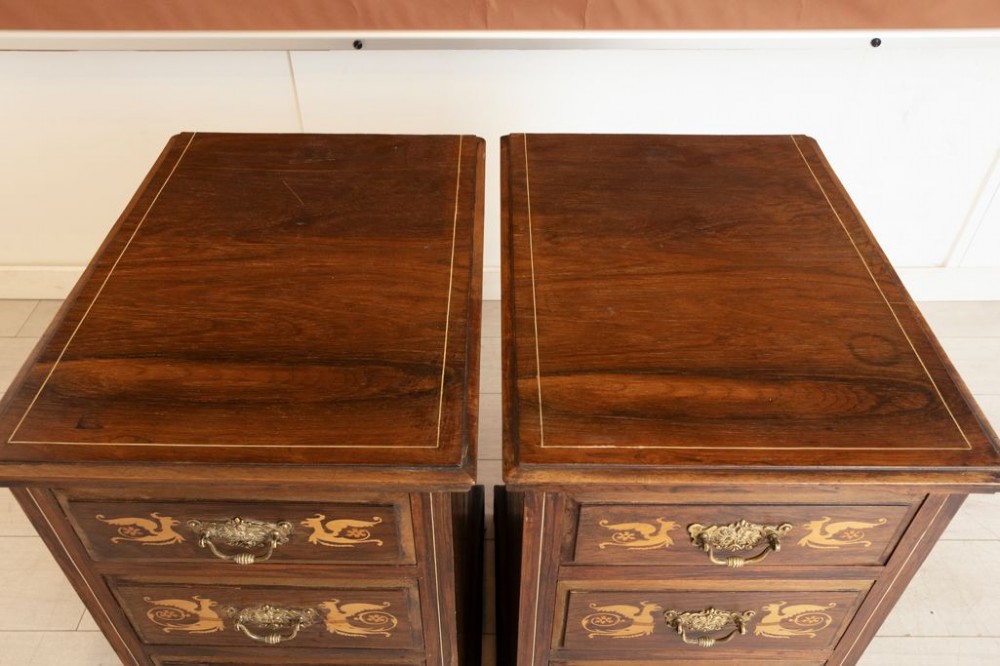 A matching pair of dark rosewood four-drawer bedside cabinets featuring floral and griffin marquetry inlays and ornate brass handles on plinth bases. View II
