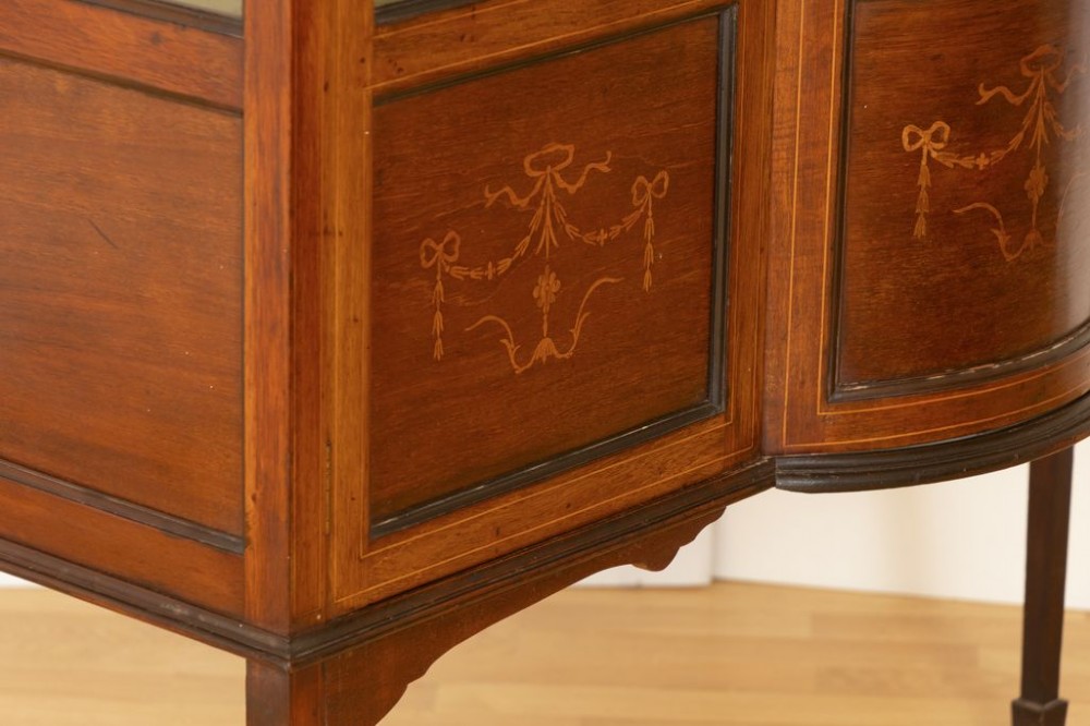 An Edwardian mahogany china cabinet featuring three glazed doors with oval astragal moulding, inlaid lower panels, and slender square legs. View III