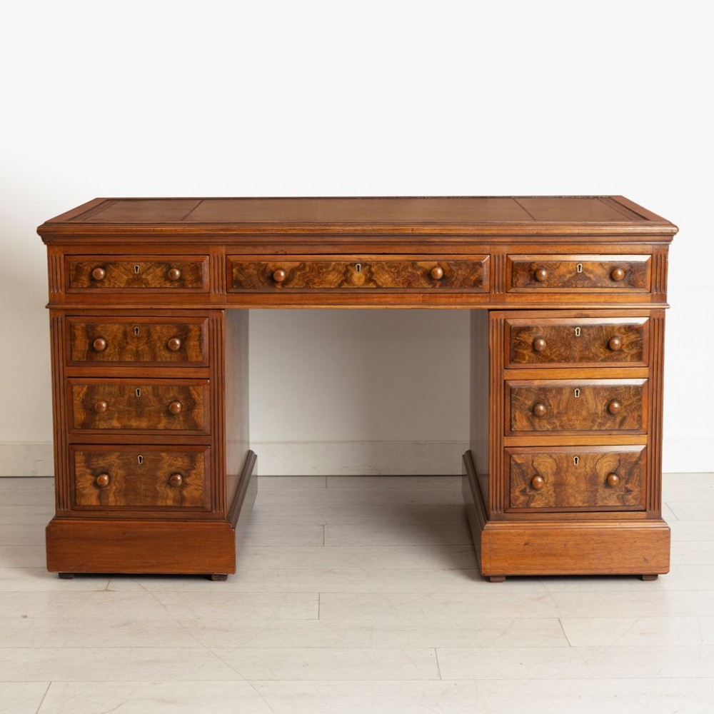 A nineteenth-century Victorian walnut pedestal desk featuring decorative burr walnut drawer fronts, turned wooden handles, a green leather writing surface, and a sturdy plinth base. View II