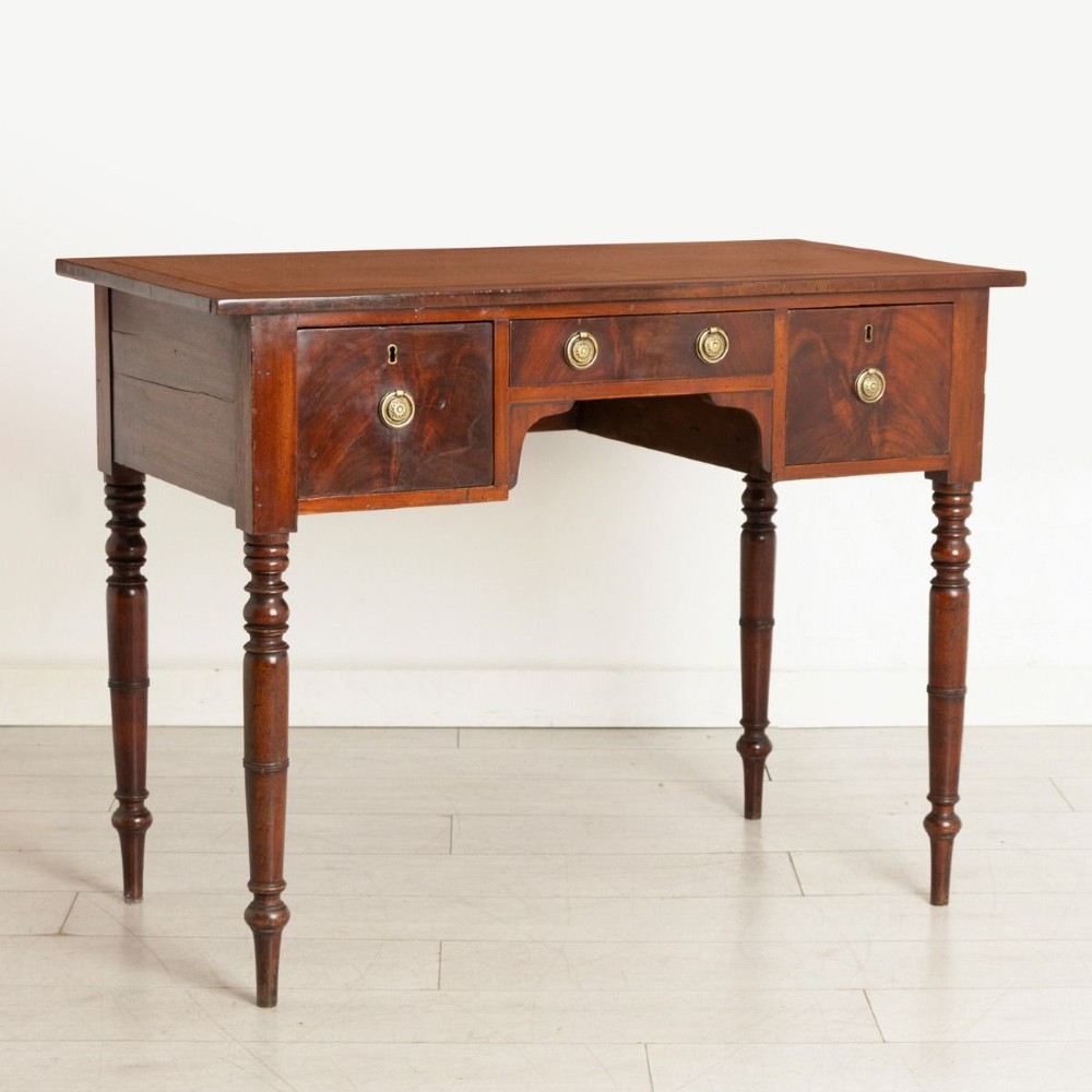 A Victorian mahogany writing desk featuring three drawers with brass ring handles, a leather-inset top, and four turned legs. View II