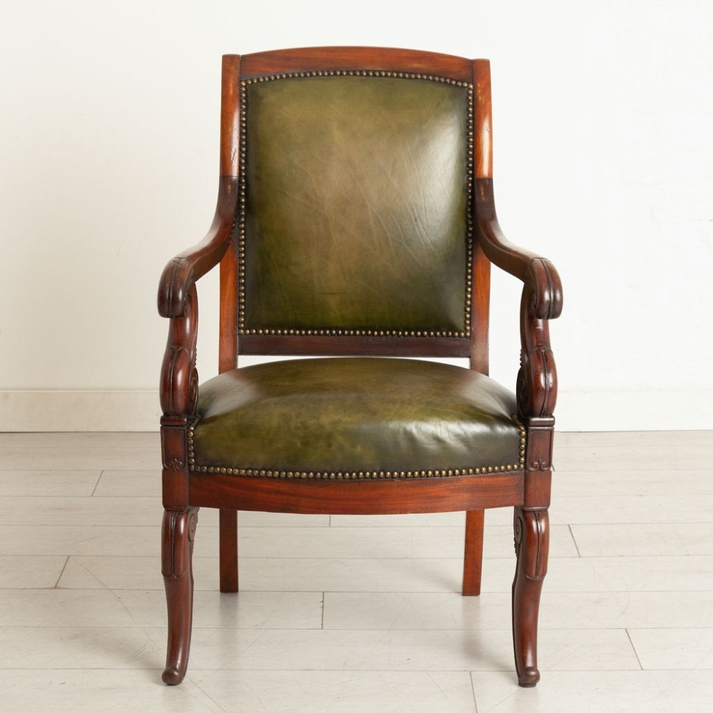 A Regency mahogany library chair featuring olive green leather upholstery with brass stud trim, carved scroll arms, and shaped legs. View II