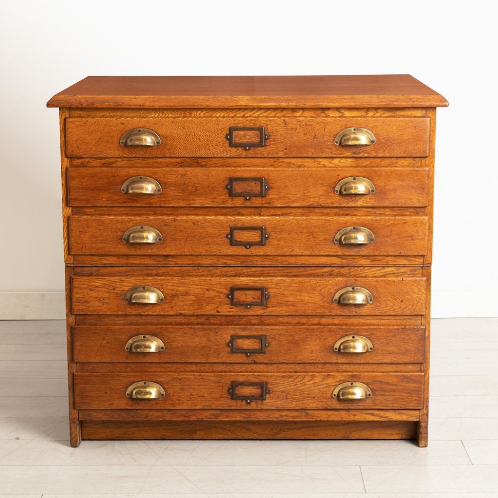 An antique golden oak plan chest featuring six wide shallow drawers arranged in two stacking sections with brass cup handles and central card index holders. View II