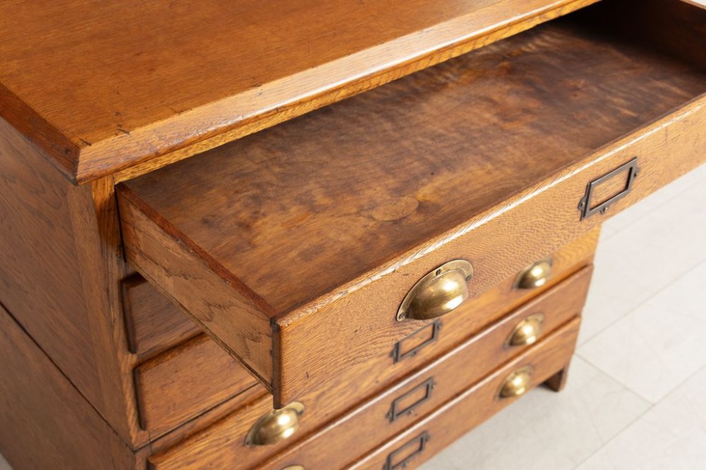 An antique golden oak plan chest featuring six wide shallow drawers arranged in two stacking sections with brass cup handles and central card index holders. View IV