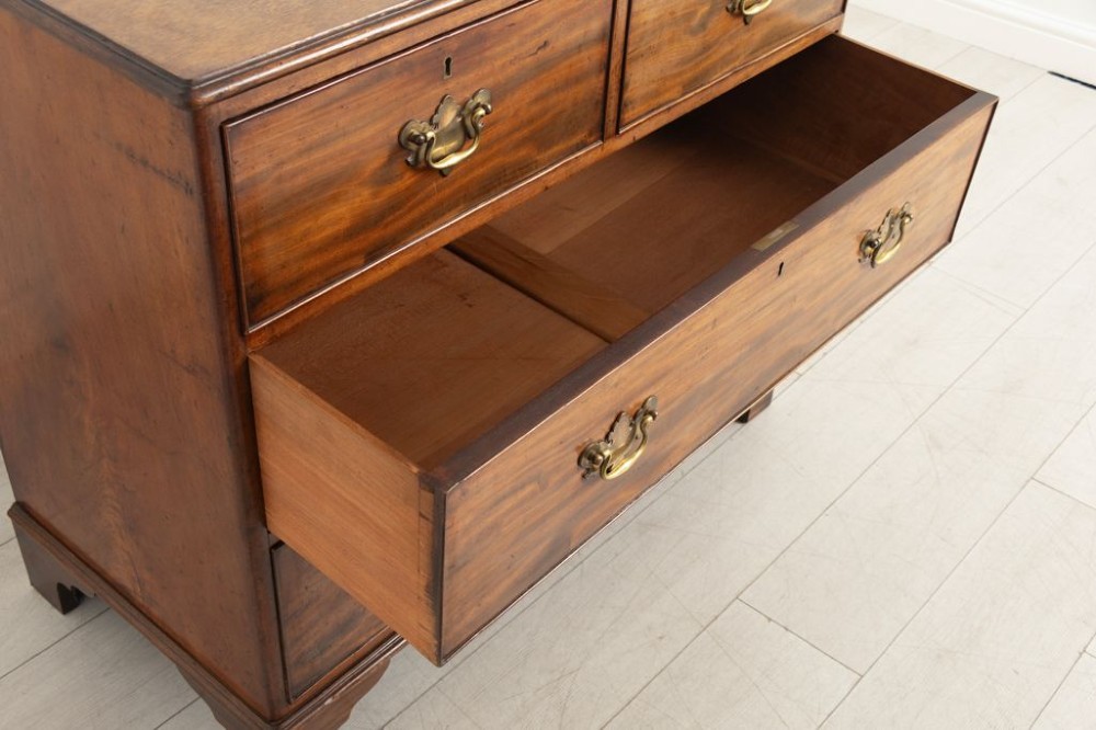 A late nineteenth-century mahogany chest of drawers featuring two short upper drawers and two long lower drawers with brass handles and shaped bracket feet. View III