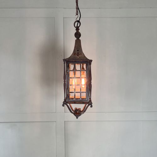 fig 1. An Edwardian rectangular brass hanging lantern light fixture with glazed window panels, internal bulb fittings, a pagoda top, and a lower scroll finial.