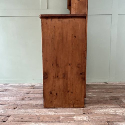 An early twentieth-century pine kitchen dresser featuring an open top display rack with two shelves above a two-door cabinet base with brass ring handles. View VIII