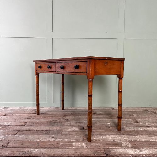 fig 1. An antique pine hall table featuring two drawers with dark turned handles and slender turned legs.