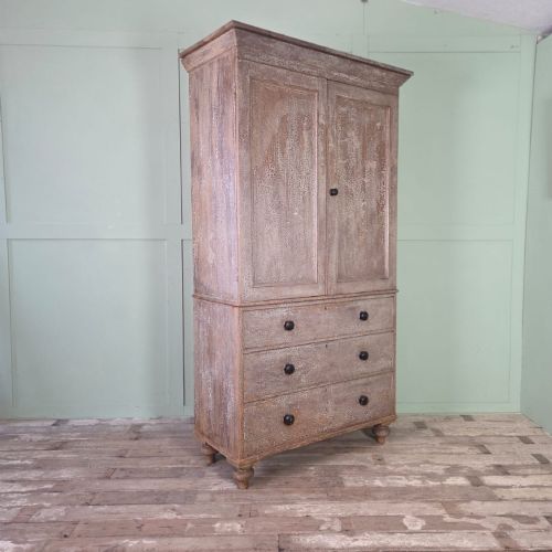 fig 1. A tall late Georgian painted pine housekeepers cupboard featuring panelled upper doors and three lower drawers on turned feet.