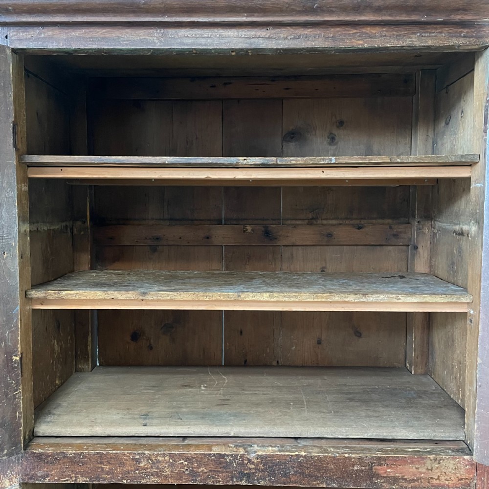 A late 18th-century dark brown painted pine food cupboard with arched mesh upper doors and fielded panel lower doors. View III