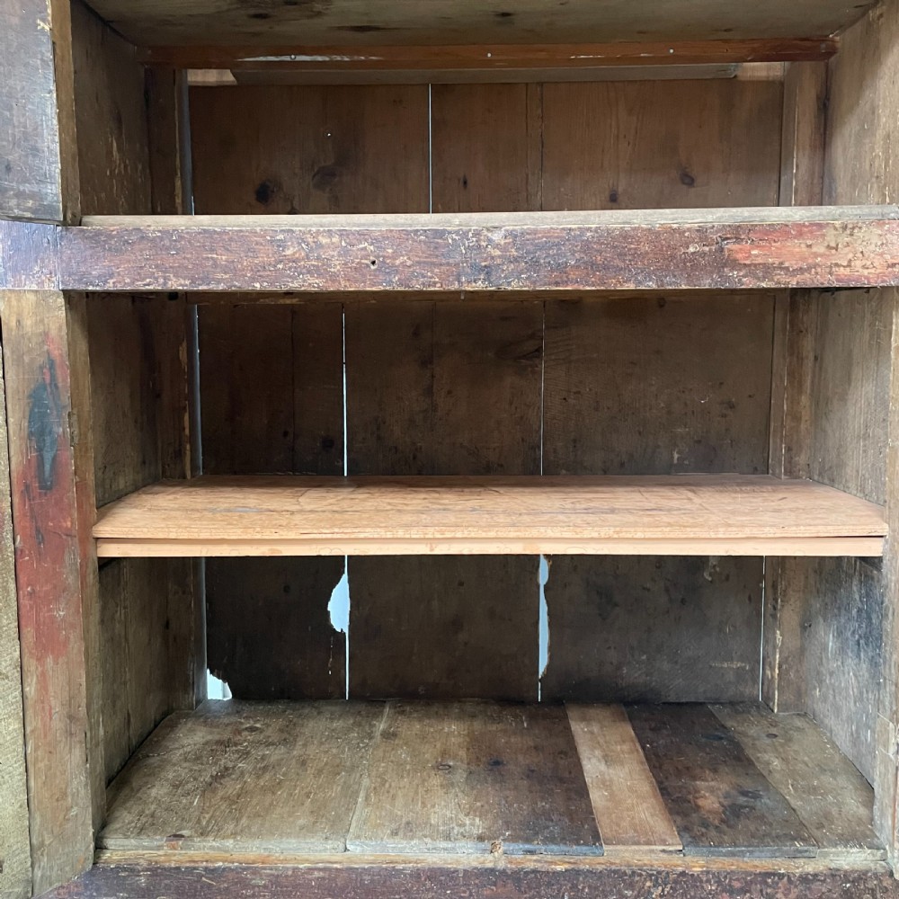 A late 18th-century dark brown painted pine food cupboard with arched mesh upper doors and fielded panel lower doors. View V