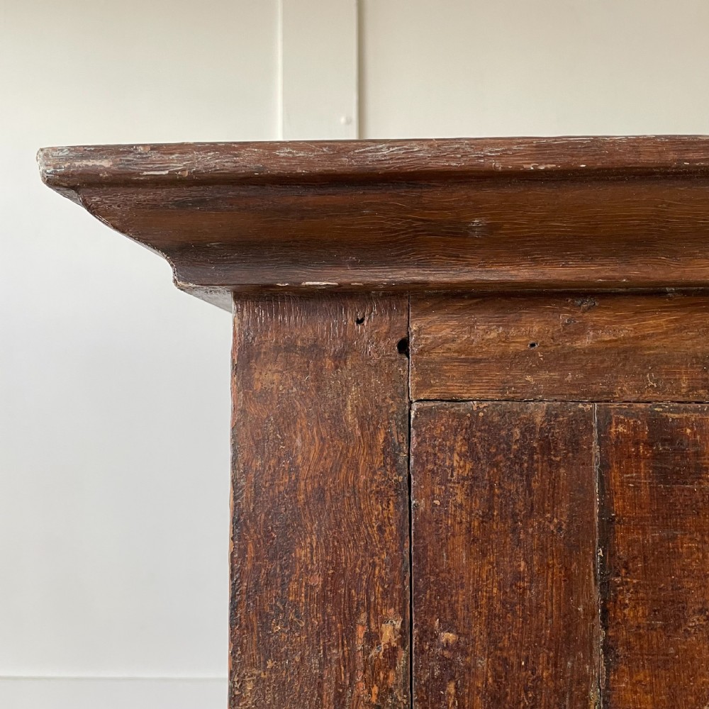 A late 18th-century dark brown painted pine food cupboard with arched mesh upper doors and fielded panel lower doors. View XI
