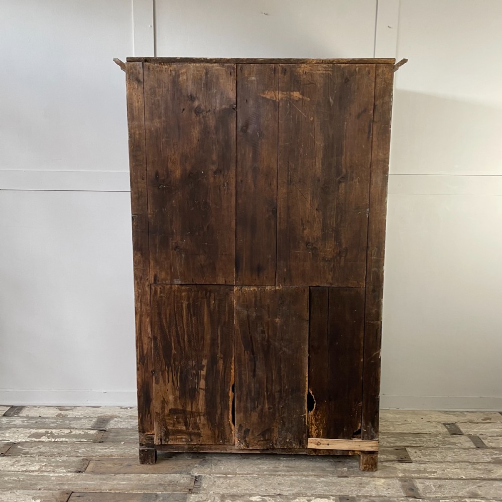 A late 18th-century dark brown painted pine food cupboard with arched mesh upper doors and fielded panel lower doors. View XVI