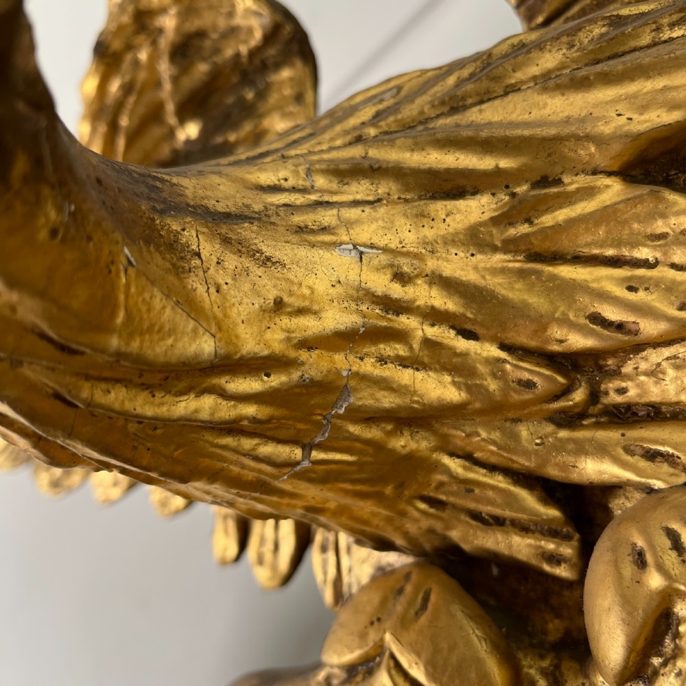 A circular carved giltwood convex wall mirror surmounted by a carved eagle crest with spread wings and an acanthus leaf apron. View IX