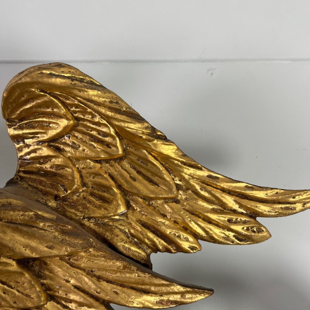 A circular carved giltwood convex wall mirror surmounted by a carved eagle crest with spread wings and an acanthus leaf apron. View XII