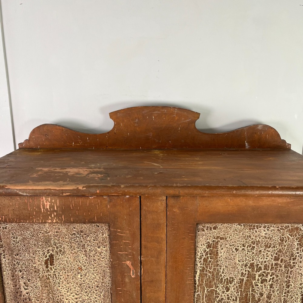 A nineteenth-century two-door pine cupboard featuring distressed crackle-glaze panel doors and a shaped cresting rail. View III