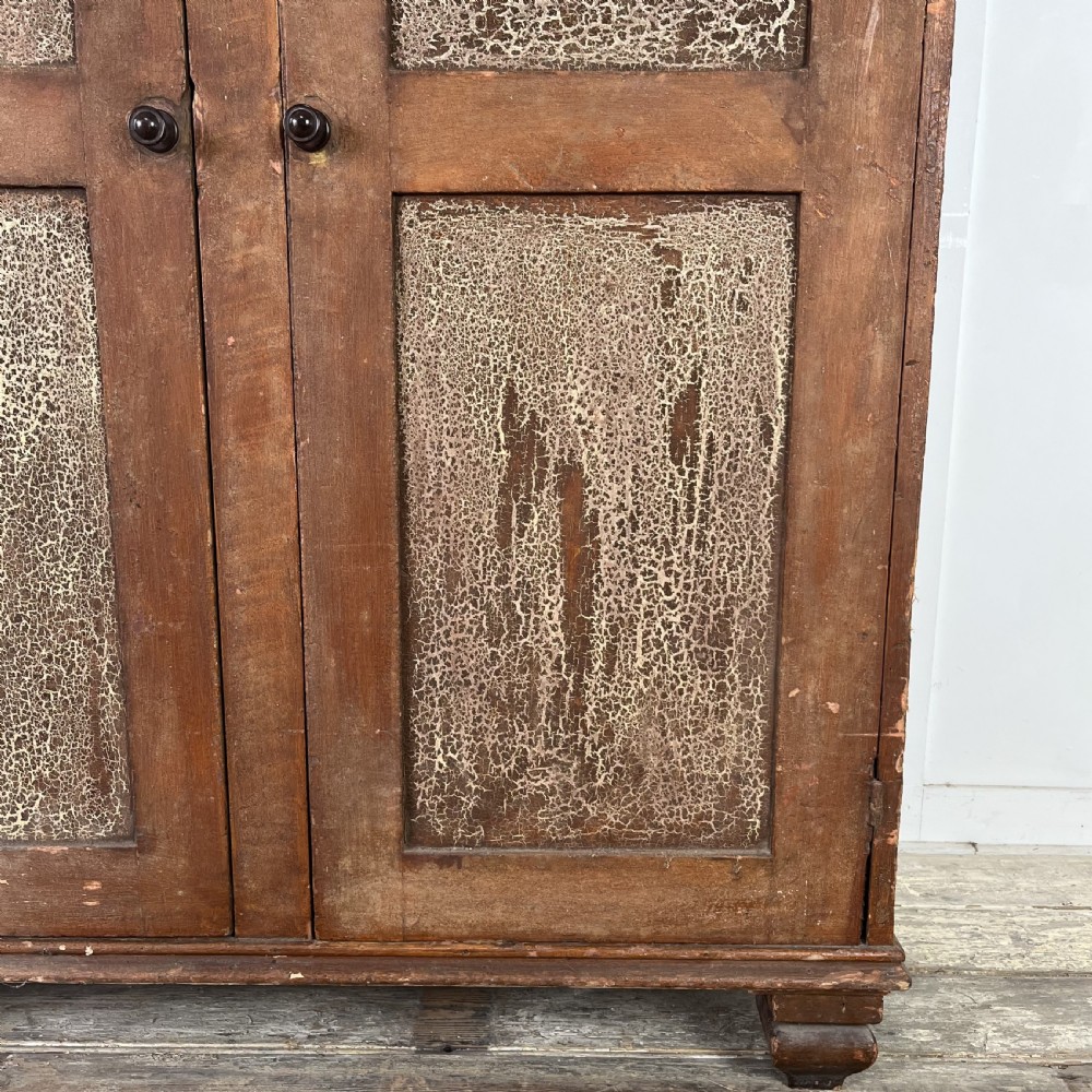 A nineteenth-century two-door pine cupboard featuring distressed crackle-glaze panel doors and a shaped cresting rail. View VI