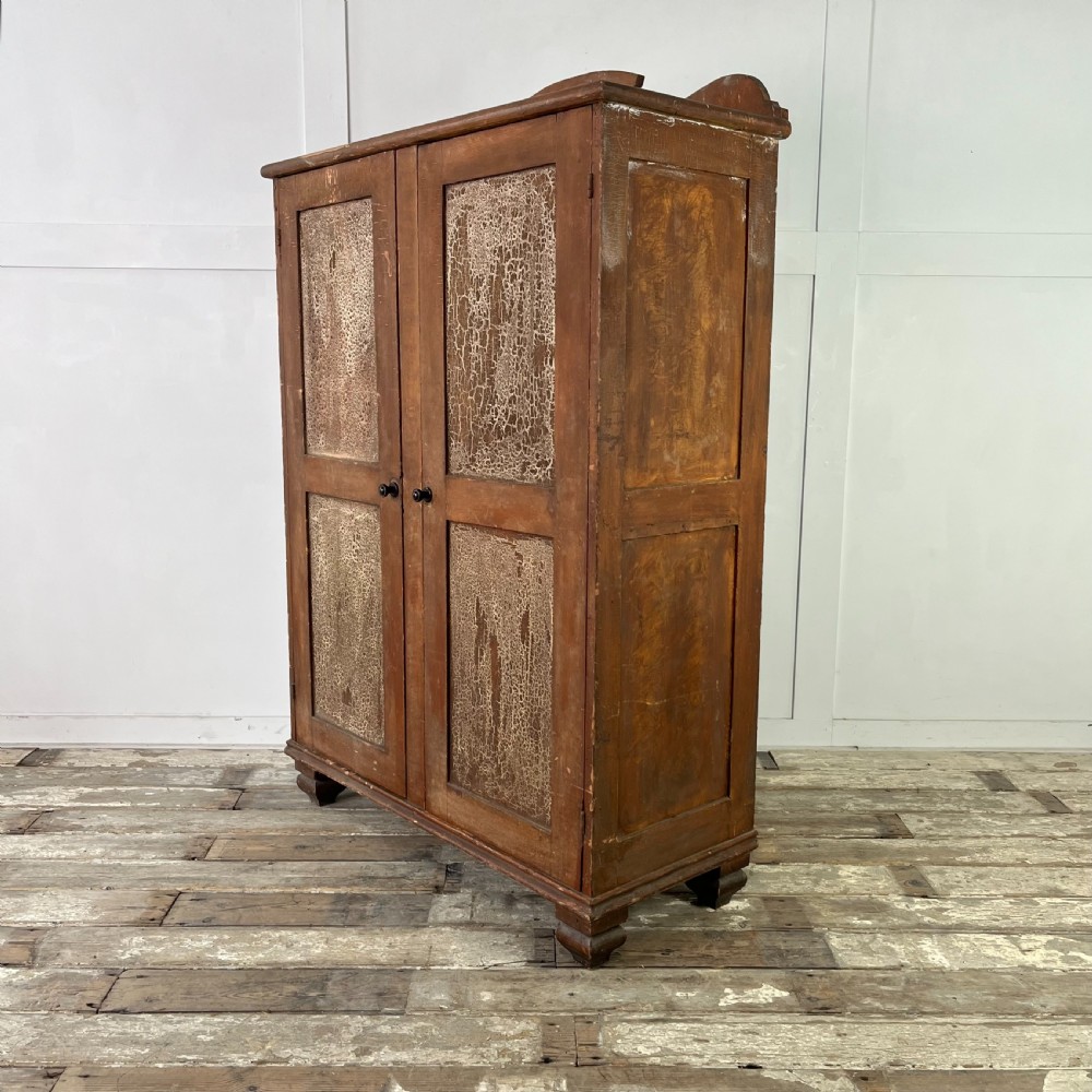 A nineteenth-century two-door pine cupboard featuring distressed crackle-glaze panel doors and a shaped cresting rail. View VIII