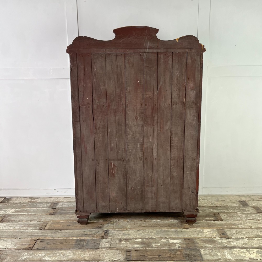 A nineteenth-century two-door pine cupboard featuring distressed crackle-glaze panel doors and a shaped cresting rail. View X