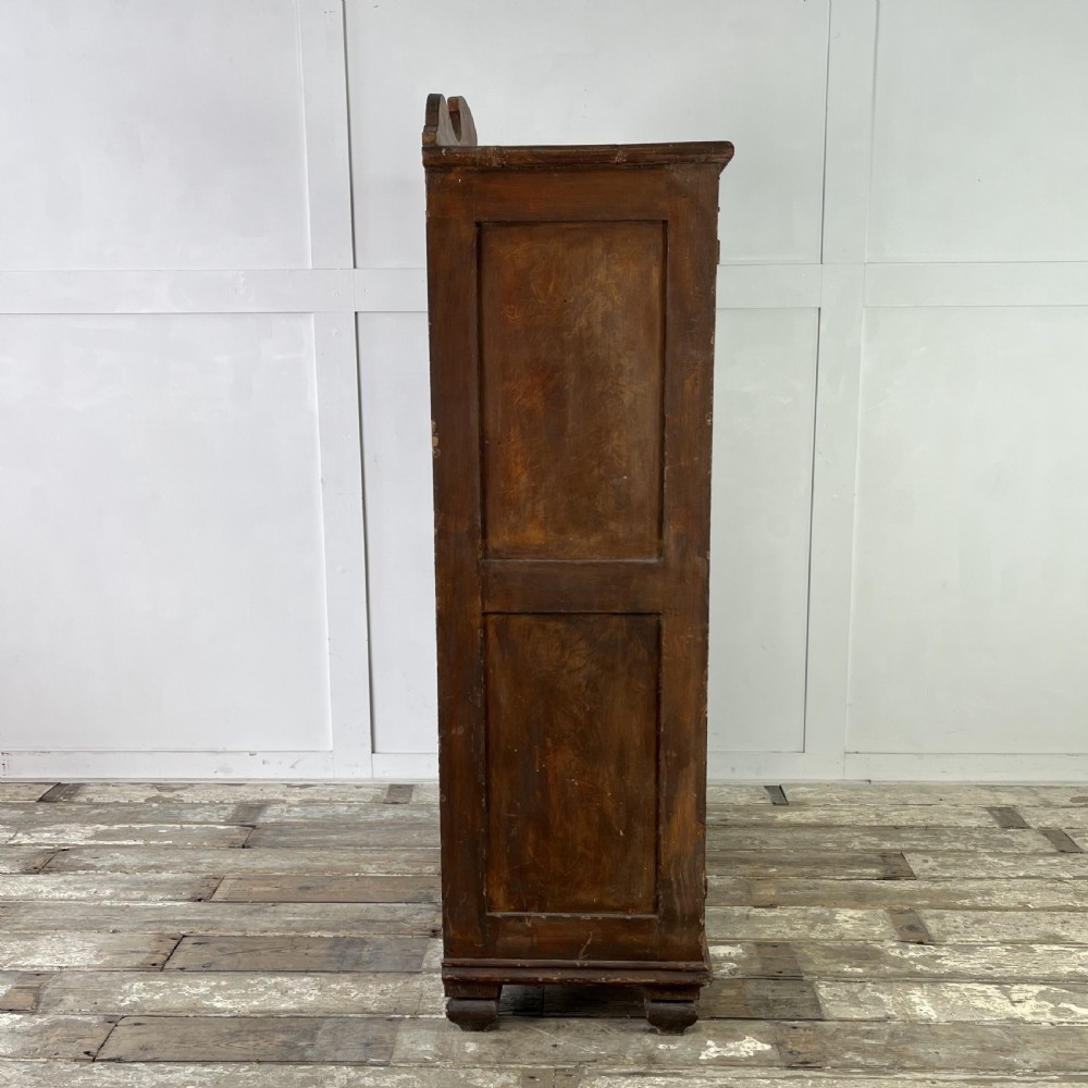 A nineteenth-century two-door pine cupboard featuring distressed crackle-glaze panel doors and a shaped cresting rail. View XI