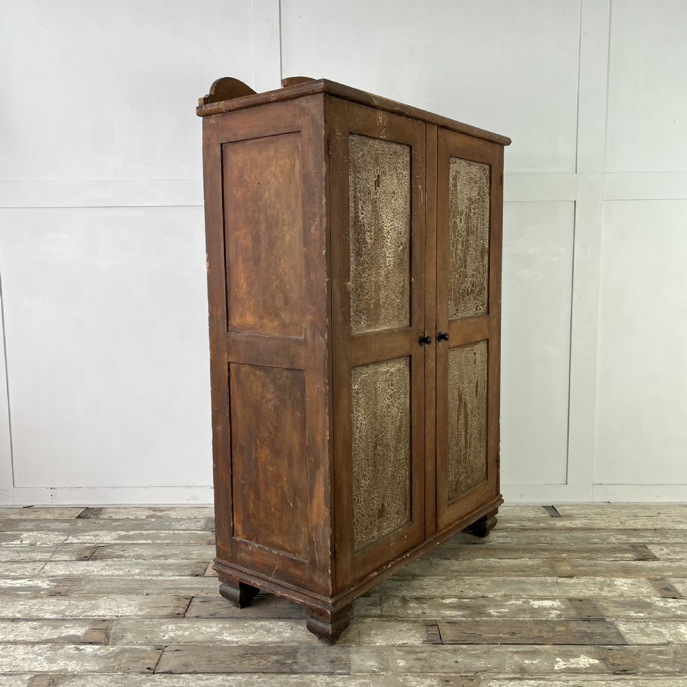A nineteenth-century two-door pine cupboard featuring distressed crackle-glaze panel doors and a shaped cresting rail. View XIV