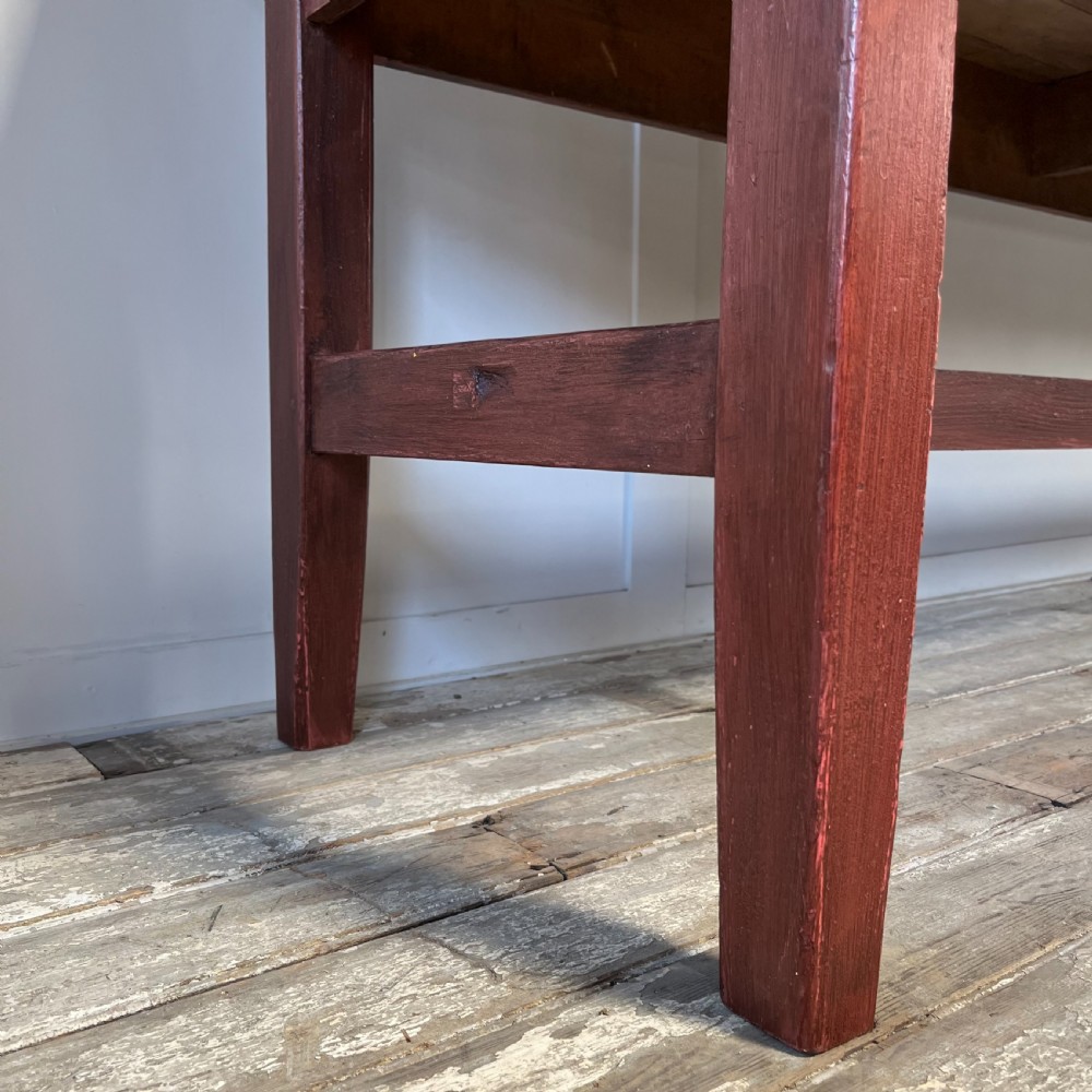 A long 19th-century Welsh pine refectory table featuring a natural timber plank top supported by a dark red painted frame with lower stretchers. View VIII