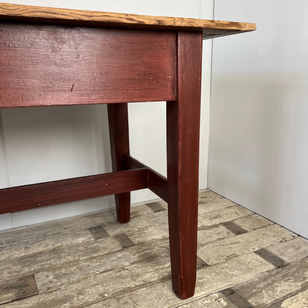 A long 19th-century Welsh pine refectory table featuring a natural timber plank top supported by a dark red painted frame with lower stretchers. View IX