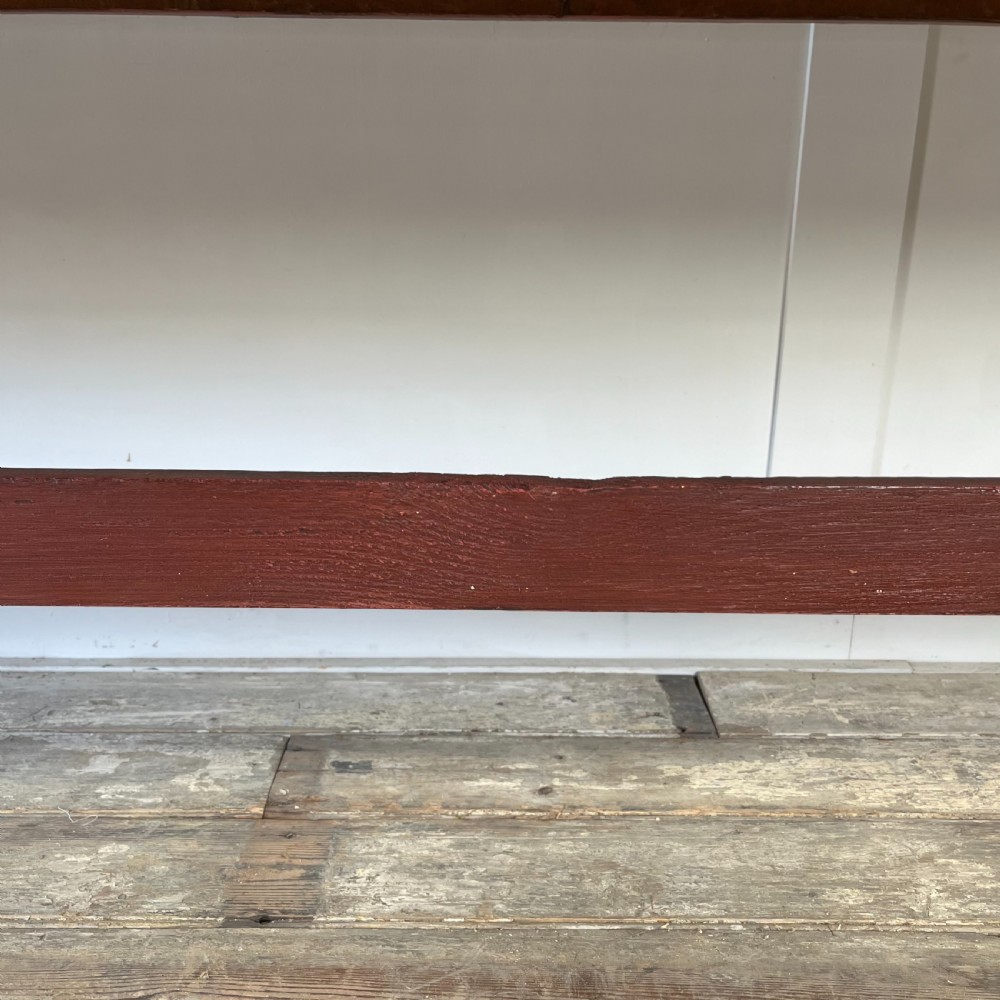 A long 19th-century Welsh pine refectory table featuring a natural timber plank top supported by a dark red painted frame with lower stretchers. View XI